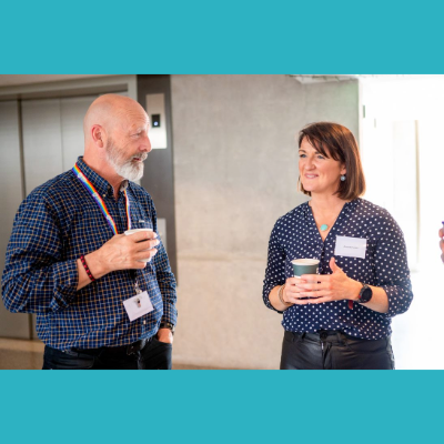 Male and Female talking at a meeting whilst on a break